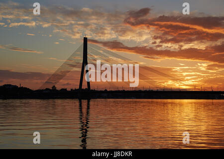 Silhouette of a cable-stayed bridge in Riga against a beautiful sunset Stock Photo