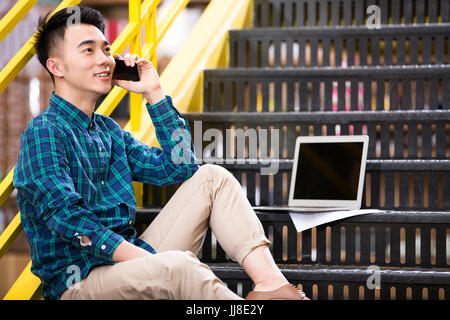 Young man on the stairs in office Stock Photo
