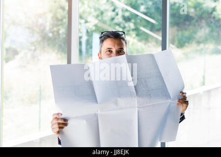 Young handsome businessman in his office studying plans. Stock Photo