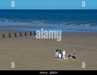 Asian family on the beach, Bridlington, East Yorkshire, England UK Stock Photo