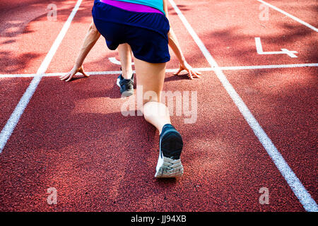 Female Hands on starting line waiting for the start in running track, workout session Stock Photo