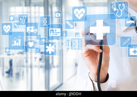 Female medical doctor hand holding stethoscope touching icons about health care services on virtual screen with hospital interior in background Stock Photo