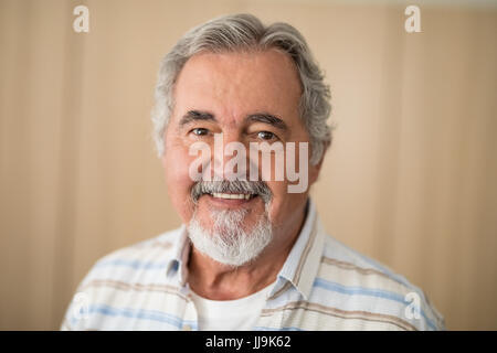 Close-up portrait of senior man against wall at retirement home Stock Photo