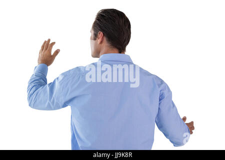 Rear view of businessman gesturing while using invisible interface Stock Photo