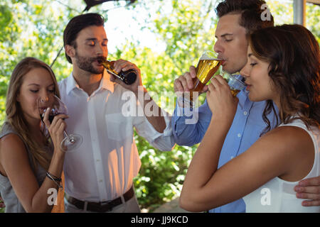 Friends having a alcohol at counter in restaurant Stock Photo