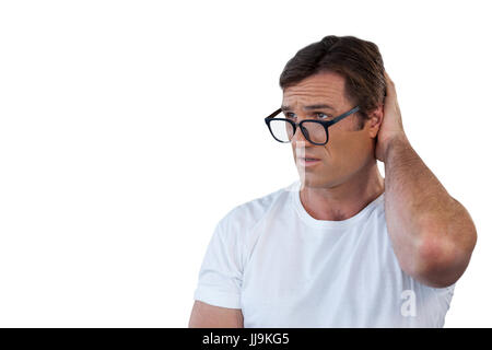 Confused mature man wearing eyeglasses scratching head against white background Stock Photo