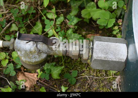 Control on off tap and filter at bottom of domestic bunded oil tank re close up industrial isolation valve heating Stock Photo