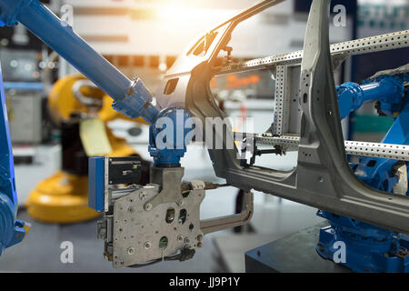 Automobile manufacturing production industrial machine , factory robot arm in smart factory and industry 4.0 concept. Flare light effect. Stock Photo