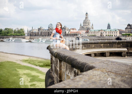 Lifestyle portrait of a stylish woman on the bridge traveling in Dresden city, Germany Stock Photo