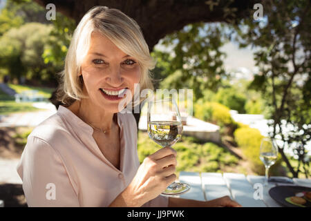 Portrait of smiling woman having glass of champagne at restaurant Stock Photo