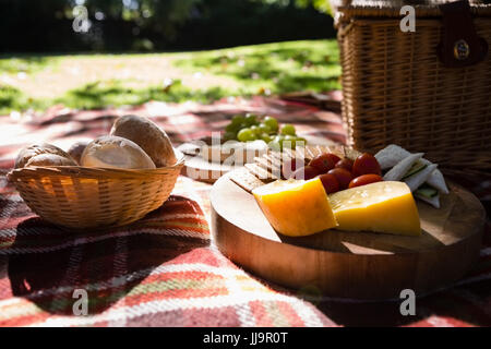 Close-up of bun, cheese, cracker biscuit on picnic blanket Stock Photo