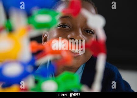 Portrait of schoolgirl experimenting molecule model against black background Stock Photo