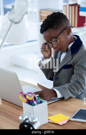 Businessman using laptop at desk in office Stock Photo