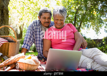 Senior couple using laptop in the garden Stock Photo