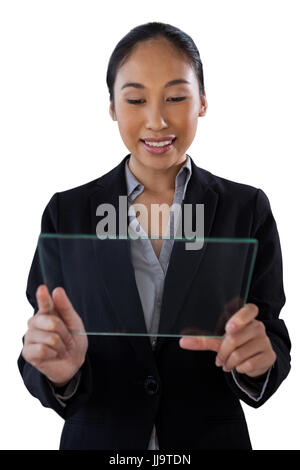 Young businesswoman holding glass interface while standing against white background Stock Photo