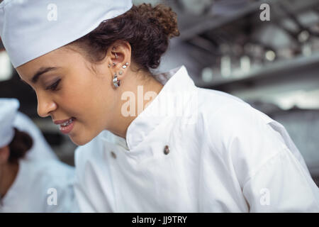 Close-up of female chef in kitchen at restaurant Stock Photo