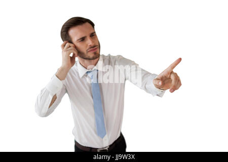 Confused businessman working on invisible interface against white background Stock Photo