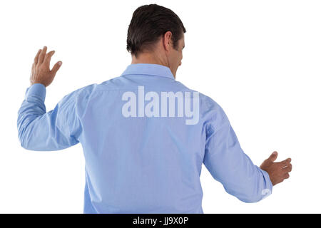 Rear view of Mature businessman gesturing while using invisible interface Stock Photo