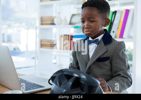Sad businessman making face while looking at laptop in office Stock Photo