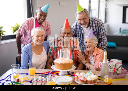 Portrait of cheerful senior people celebrating birthday at nursing home Stock Photo