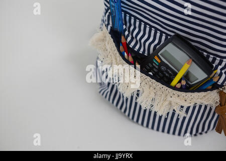 Close-up of schoolbag with various supplies on white background Stock Photo