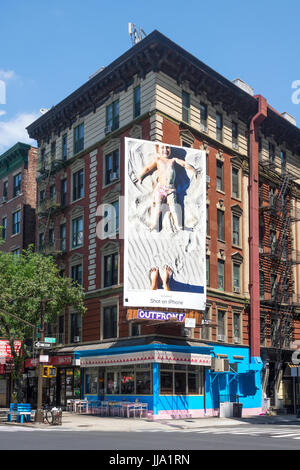 A giant billboard advertisement for the camera on the iPhone 7 hanging on the side of a small building in SoHo, New York, NY Stock Photo