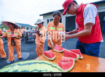 Yuyao, China's Zhejiang Province. 19th July, 2017. Volunteers send watermelons and medicine to the garbage collectors working in the sweltering heat in Yuyao City, east China's Zhejiang Province, July 19, 2017. Credit: Xu Yu/Xinhua/Alamy Live News Stock Photo