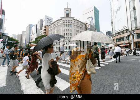 Tokyo, Japan. 19th July, 2017. Pedestrians holding parasols walk in summer heat in Ginza shopping district on July 19, 2017, Tokyo, Japan. The Japanese Meteorological Agency announced the end of the rainy season in Tokyo and surrounding prefectures. This year the rainy season ended earlier in Kanto, Koshin and Tokai regions. Credit: Rodrigo Reyes Marin/AFLO/Alamy Live News Stock Photo