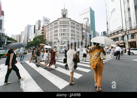 Tokyo, Japan. 19th July, 2017. Pedestrians holding parasols walk in summer heat in Ginza shopping district on July 19, 2017, Tokyo, Japan. The Japanese Meteorological Agency announced the end of the rainy season in Tokyo and surrounding prefectures. This year the rainy season ended earlier in Kanto, Koshin and Tokai regions. Credit: Rodrigo Reyes Marin/AFLO/Alamy Live News Stock Photo