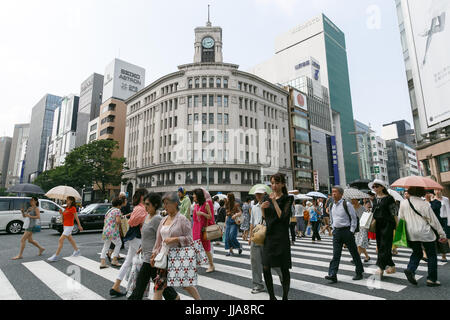 Tokyo, Japan. 19th July, 2017. Pedestrians holding parasols walk in summer heat in Ginza shopping district on July 19, 2017, Tokyo, Japan. The Japanese Meteorological Agency announced the end of the rainy season in Tokyo and surrounding prefectures. This year the rainy season ended earlier in Kanto, Koshin and Tokai regions. Credit: Rodrigo Reyes Marin/AFLO/Alamy Live News Stock Photo