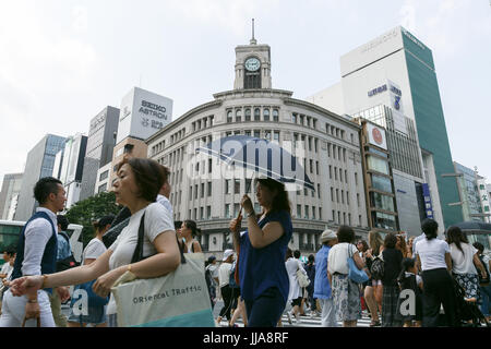 Tokyo, Japan. 19th July, 2017. Pedestrians holding parasols walk in summer heat in Ginza shopping district on July 19, 2017, Tokyo, Japan. The Japanese Meteorological Agency announced the end of the rainy season in Tokyo and surrounding prefectures. This year the rainy season ended earlier in Kanto, Koshin and Tokai regions. Credit: Rodrigo Reyes Marin/AFLO/Alamy Live News Stock Photo