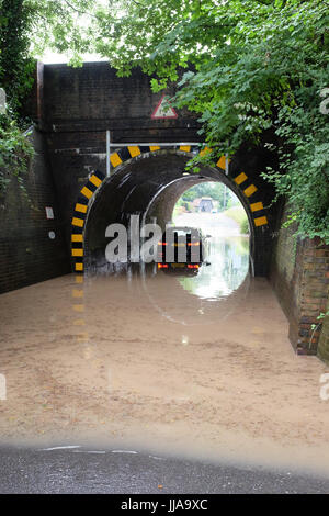 Basing, Hampshire. 19th July, 2017. A driver waits for help on Wednesday morning after their car gets stuck in a flood beneath a railway bridge in the village of Basing, near Basingstoke in Hampshire. Overnight storms caused widespread damage across the south of the country. Credit: Trevor Mogg / Alamy Live News Stock Photo