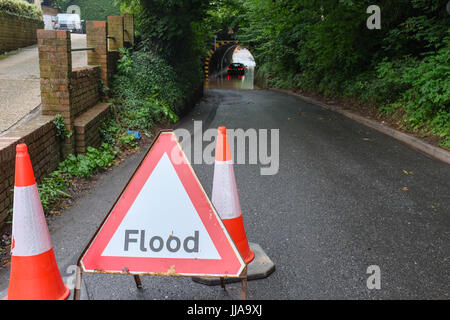 Basing, Hampshire. 19th July, 2017. A driver waits for help on Wednesday morning after their car gets stuck in a flood beneath a railway bridge in the village of Basing, near Basingstoke in Hampshire. Overnight storms caused widespread damage across the south of the country. Credit: Trevor Mogg / Alamy Live News Stock Photo