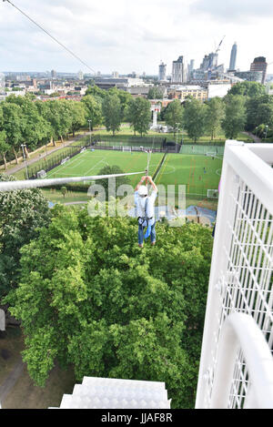 London, UK. 19th July, 2017. A brave participant rides a newly installed 225m long zip wire in Archbishop's Park on the South Bank. Descending from the top of a 35m tower, riders are afforded bird's eye view of the capital. Called Zip World London, the rides are offered to the public until 1 October 2017. Credit: Stephen Chung/Alamy Live News Stock Photo