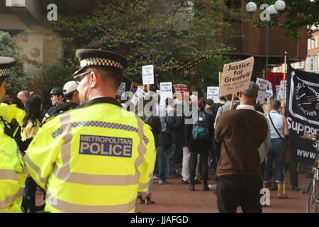London, UK. 19th July 2017. Police look on as  protests take place outside the Kensington and Chelsea Council building as the council meets to  discuss the Grenfell disaster a month after it happened. Roland Ravenhill/Alamy Live News. Credit: Roland Ravenhill/Alamy Live News Stock Photo