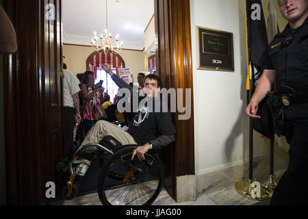 Washington, District Of Columbia, USA. 19th July, 2017. Activist NICK HOLZTHUM of Florida blocks the entrance to Sen. Marco Rubio's (R-FL) office in the Russell Senate Office Building on Capitol Hill as protesters chant inside. The protesters oppose a senate republican effort to repeal and replace the Affordable Care Act also known as Obama Care. Credit: Alex Edelman/ZUMA Wire/Alamy Live News Stock Photo