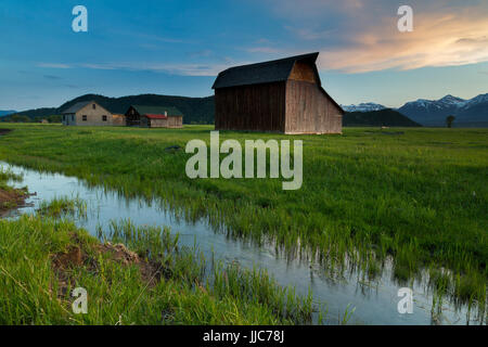 A series of houses and barns on the north end of Mormon Row and Jackson Hole in front of the Teton Mountains. Grand Teton National Park, Wyoming Stock Photo