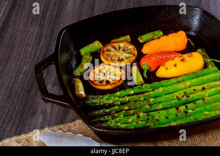 grilled organic asparagus with lemon pepper in a frying pan Stock Photo