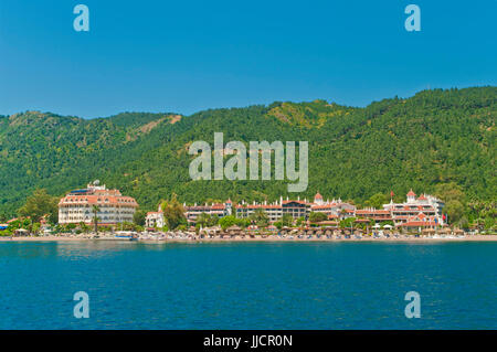 view of holiday resorts and Icmeler beach from sea on sunny day with green mountans at background, Marmaris, Turkey Stock Photo