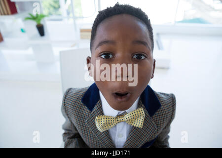 Close up portrait of boy imitating as businessman in office Stock Photo