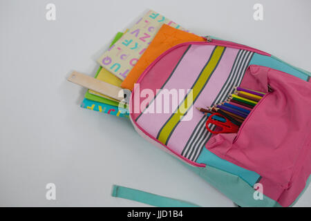 Close-up of schoolbag with various supplies on white background Stock Photo