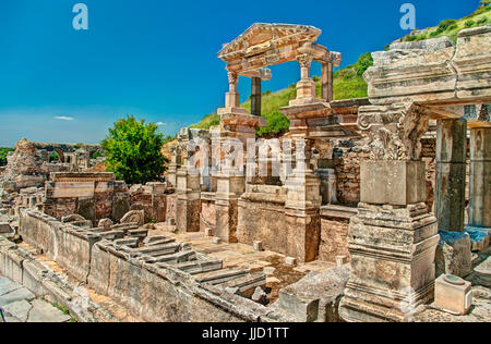 Fountain of Trajan in Ephesus with green hill in background and clear blue sky, Turkey Stock Photo