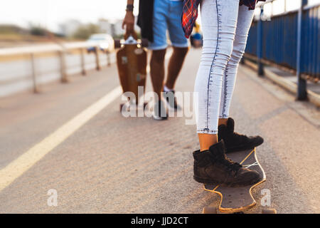 Young attractive couple riding skateboards and having fun Stock Photo