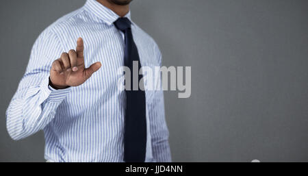 Mid section of businessman using invisible screen  against grey background Stock Photo