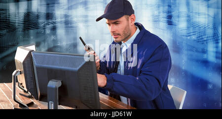 Focused security officer looking observing computer monitors and talking on walkie talkie against virus background Stock Photo