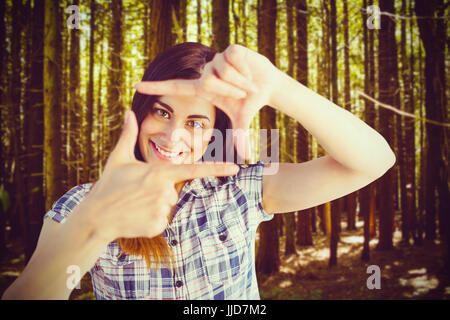 Portrait of woman looking through hands  against trees in a woods Stock Photo