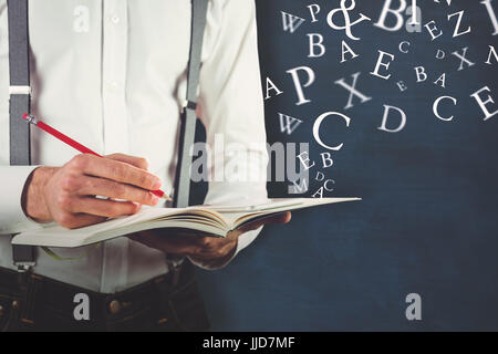 Mid section of man writing on book against letters Stock Photo