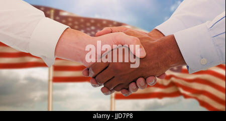 Close-up shot of a handshake in office against composite image of close up of the us flag Stock Photo