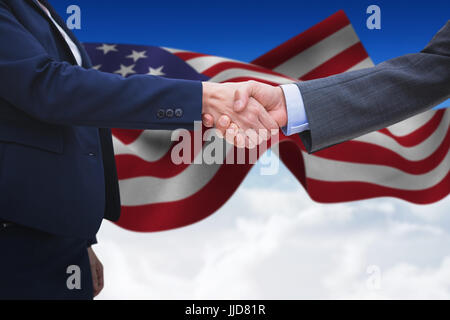 Entrepreneurs shaking hands against blue sky over clouds Stock Photo