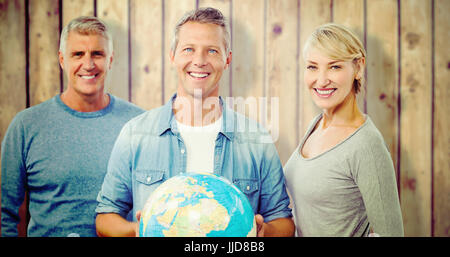 Portrait of people with globe  against wooden planks Stock Photo